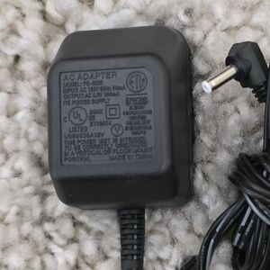 Source Unknown Black AC Adapter with Black Cable. Output 8 Volt 300 ma.
